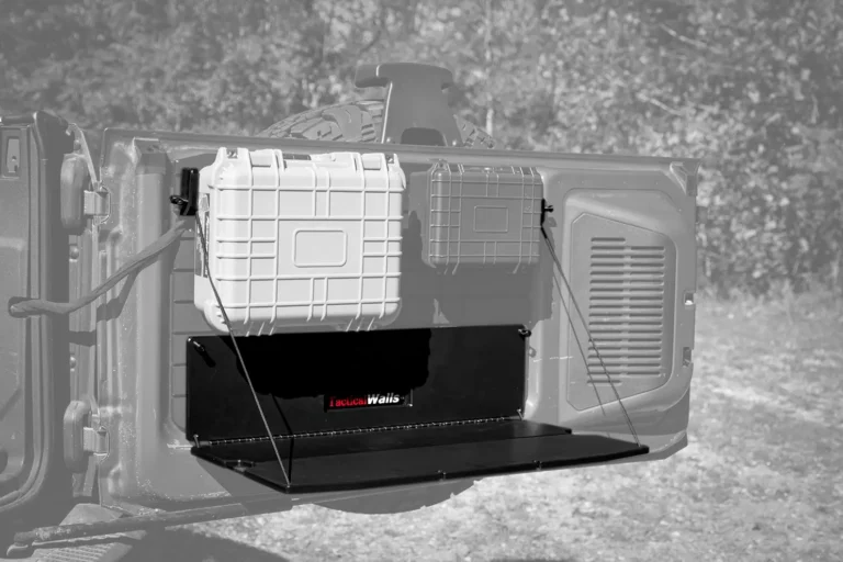 Grayscale-style view of the Ford Bronco Tailgate Table deployed as a workspace with two storage cases attached to the tailgate system.