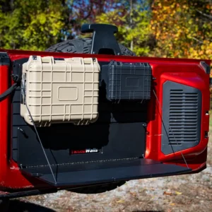 A picture of the Bronco Tailgate Table unfolded while installed on a red Bronco with two cases installed above it.