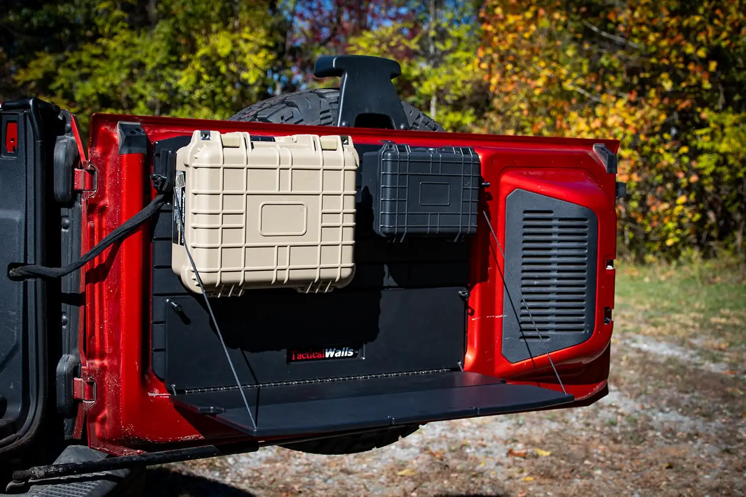 Ford Bronco Tailgate Table A picture of the Bronco Tailgate Table unfolded while installed on a red Bronco with two cases installed above it.