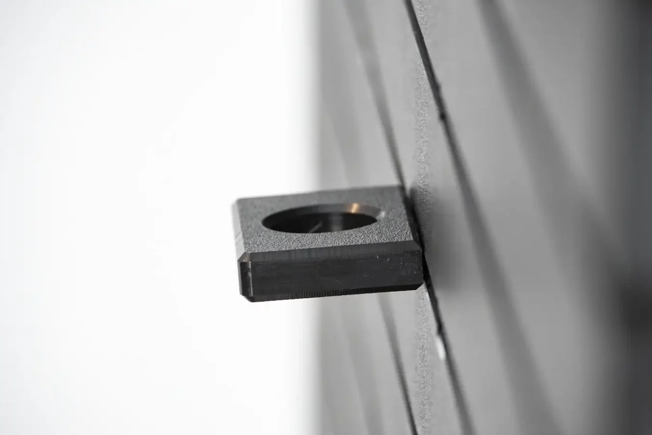 ModWall Flashlight Holder Close-up side view of the black HDPE ModWall Flashlight Holder mounted to a black modular panel, showing the 1-inch universal port designed for secure, rattle-free gear storage.