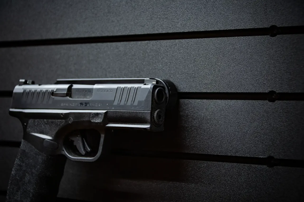 ModWall Hide-A-Mag A close-up of a handgun magnetically mounted flush against a black modular panel, highlighting the rattle-free, finish-safe construction of the ModWall Hide-A-Mag.