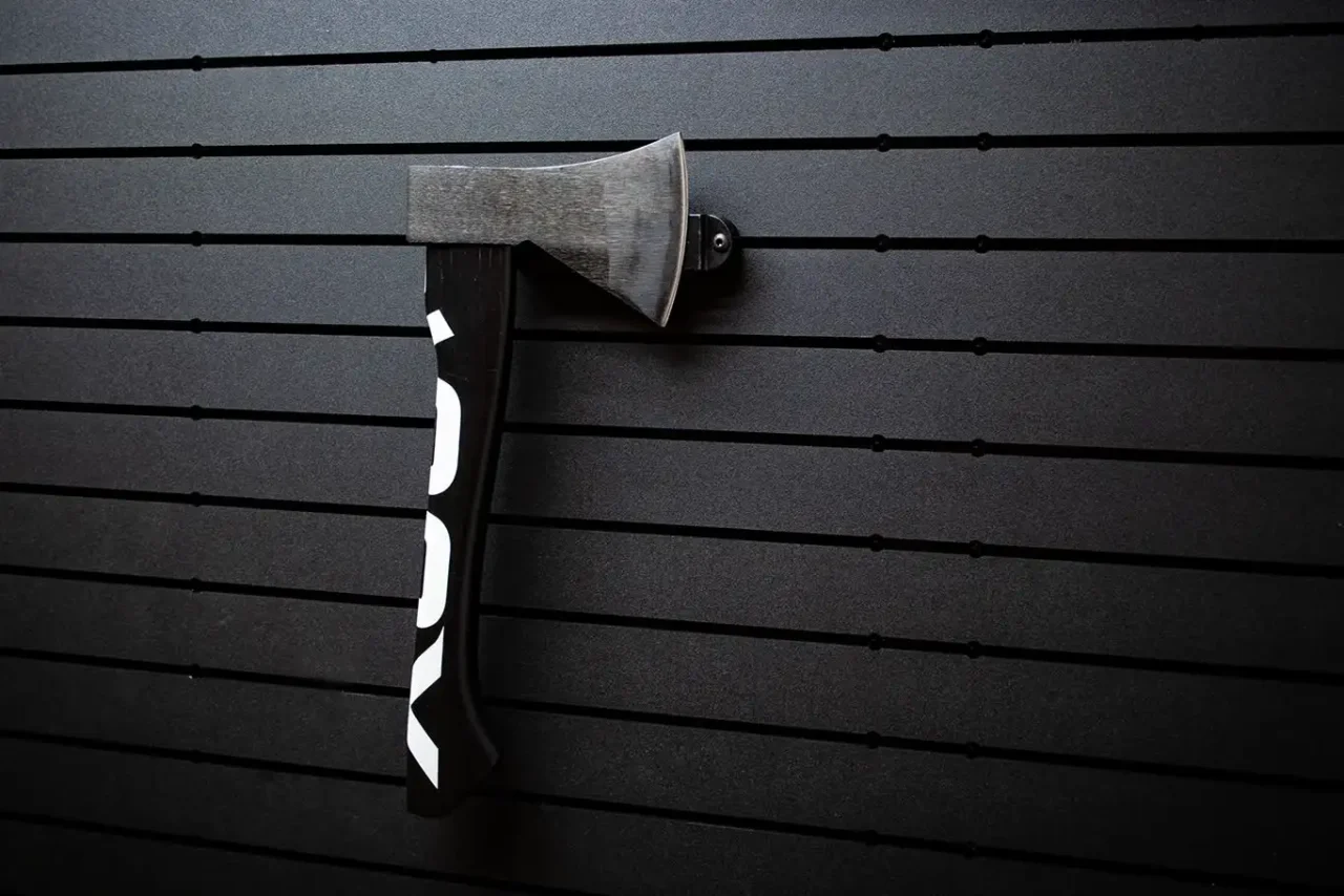 ModWall Hide-A-Mag A black and white hatchet magnetically secured to a modular vehicle panel using the Hide-A-Mag, demonstrating the high-strength magnetism required for aggressive off-road driving.