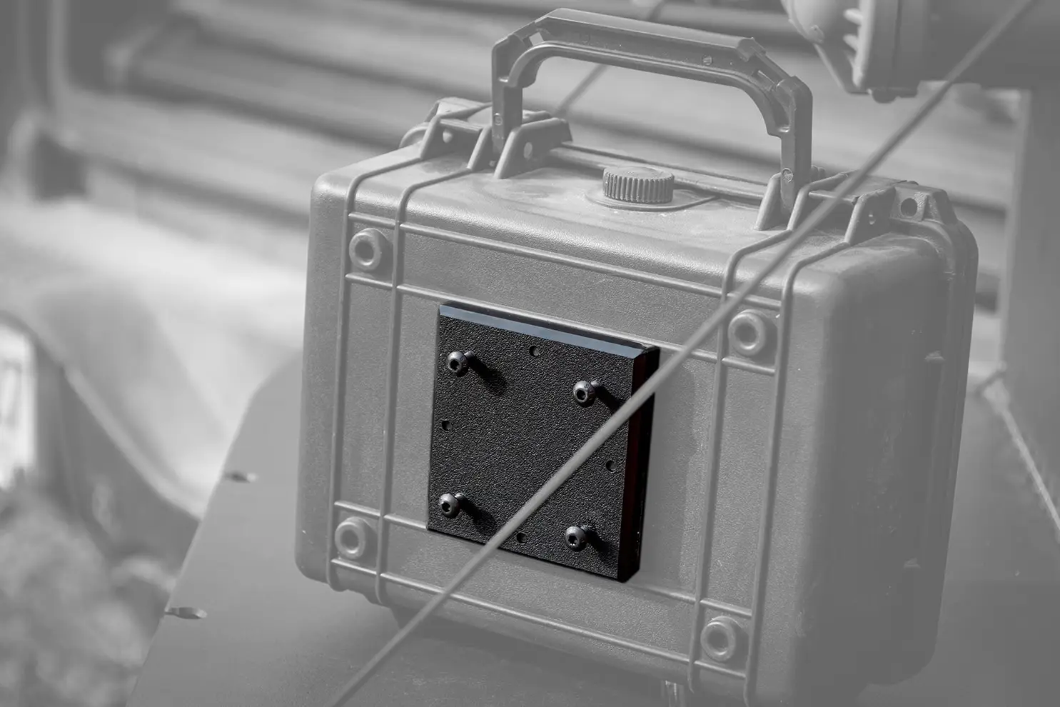 ModWall Case Adapter A grey-scale closeup of the case plate installed onto the back of an Apache storage case box.